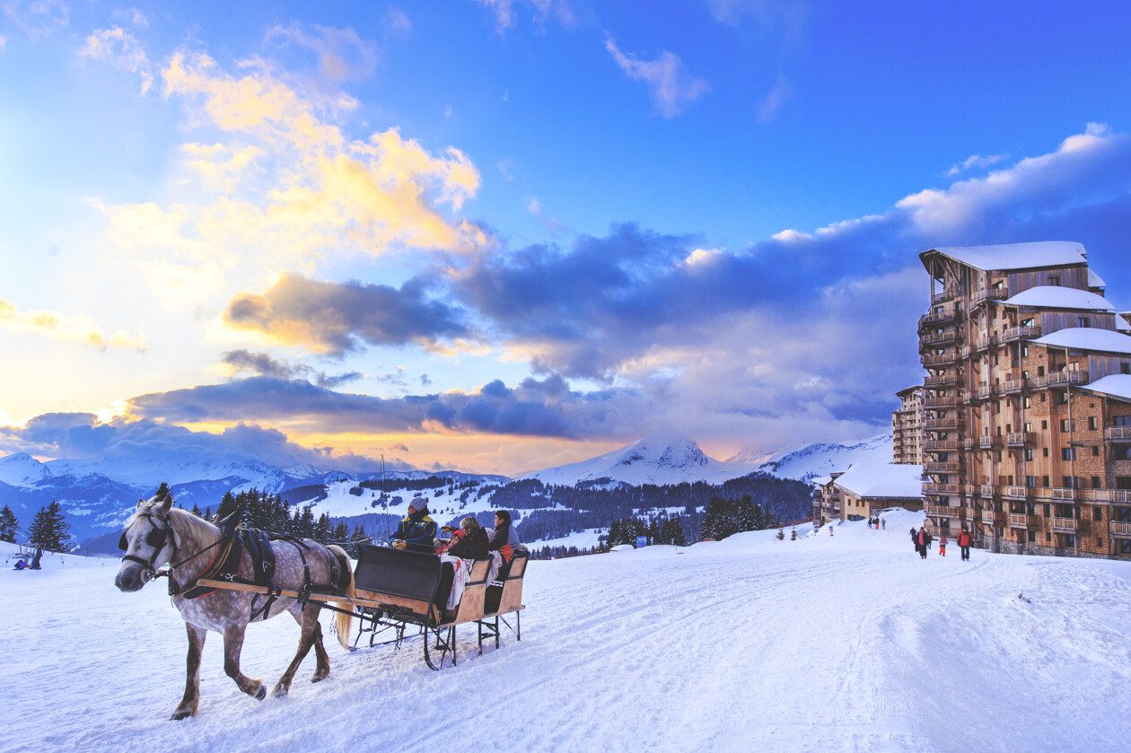 Rue animée de Morzine avec des fleurs colorées et des bâtiments montagnards.