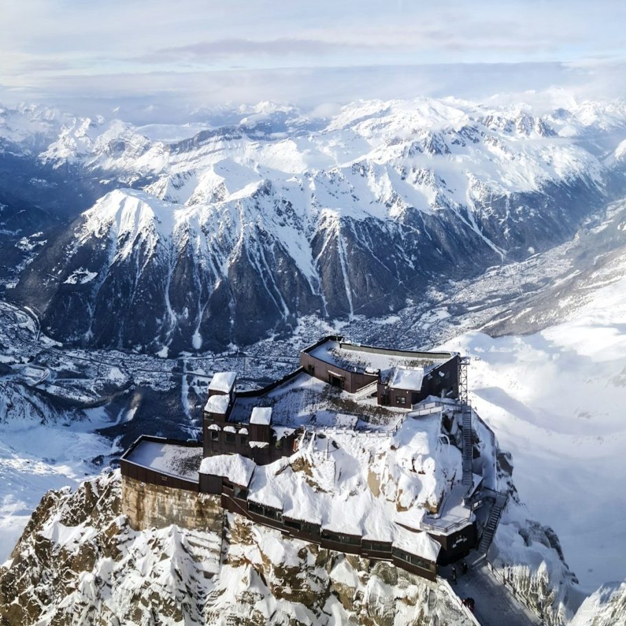 Vue panoramique d'un château en montagne, entouré de paysages enneigés.